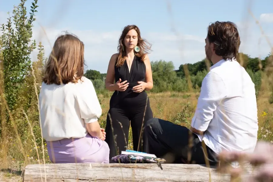 Griet Alice begeleidt een oefening voor twee mensen in de natuur