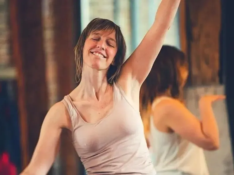 Een jonge vrouw danst met haar ogen gesloten.